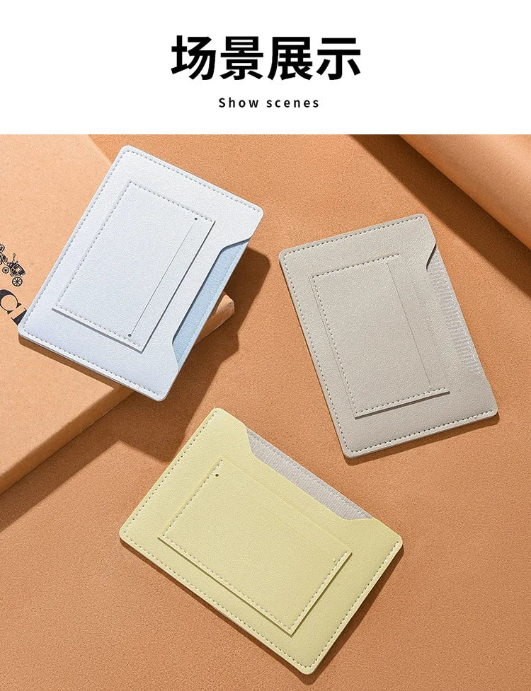 Trois porte-cartes ou portefeuilles de voyage fins de couleur claire sur une surface beige.