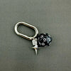 A silver-toned keychain featuring a black and white dice charm with a star pendant.