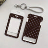 A dark brown card holder with a star pattern and a white insert is shown next to a silver retractable lanyard.