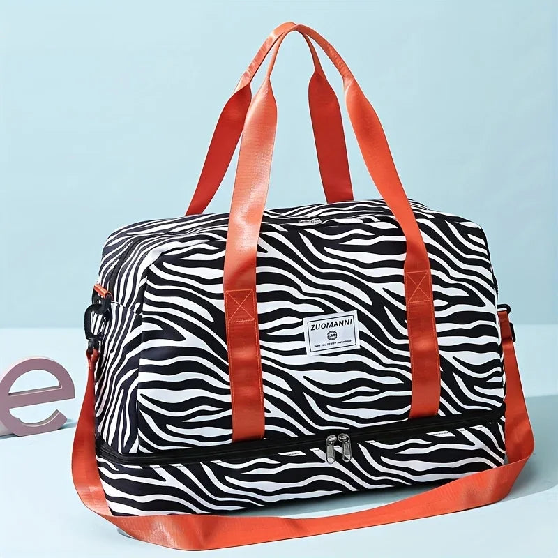 An orange nylon travel duffle bag with a black and white zebra stripe pattern.