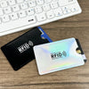 A black RFID blocking card sleeve is placed next to a white laptop keyboard.