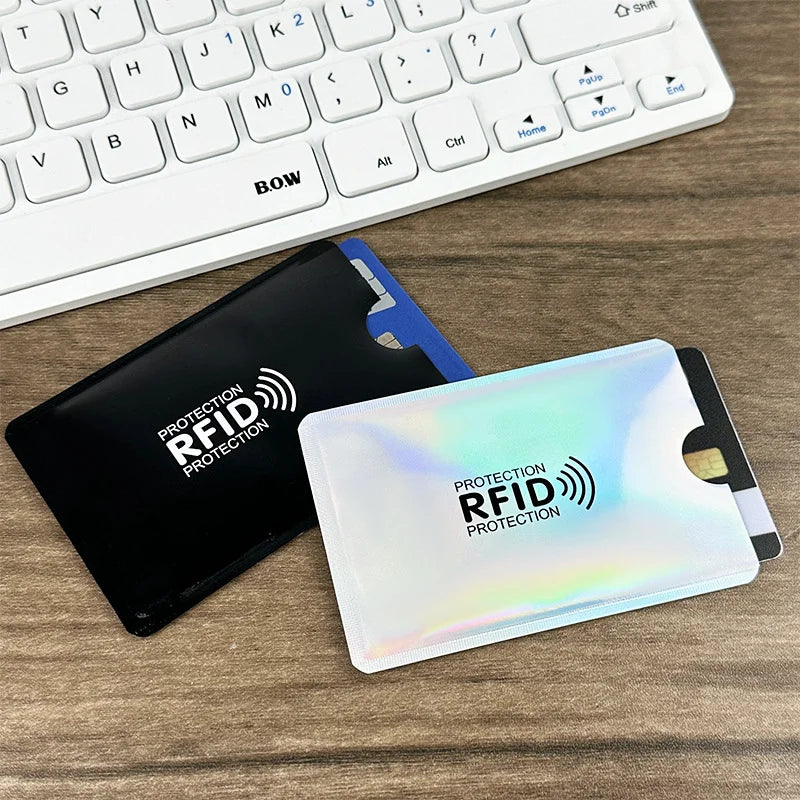 A black RFID blocking card sleeve is placed next to a white laptop keyboard.