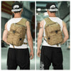 A person wearing a beige sling backpack is shown from the back, standing indoors.