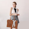 A woman models a brown vintage PU leather laptop tote bag with a white scarf and clutch.