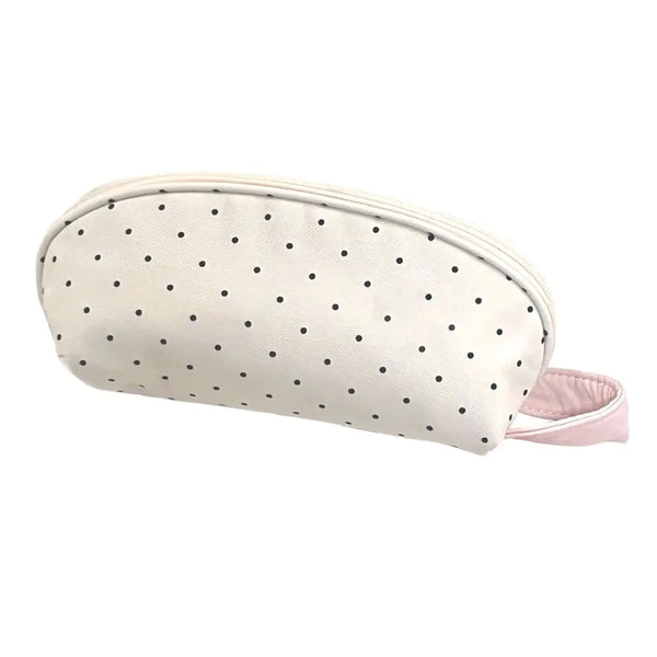 Étui à crayon en coquillage rose pâle à pois avec une sangle en tissu rose.