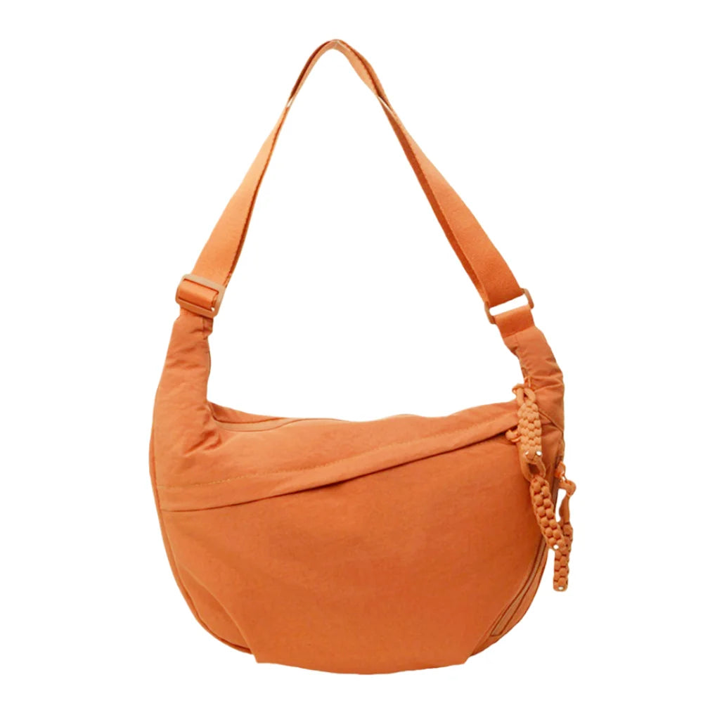 A tan canvas crossbody shoulder bag with a drawstring closure.