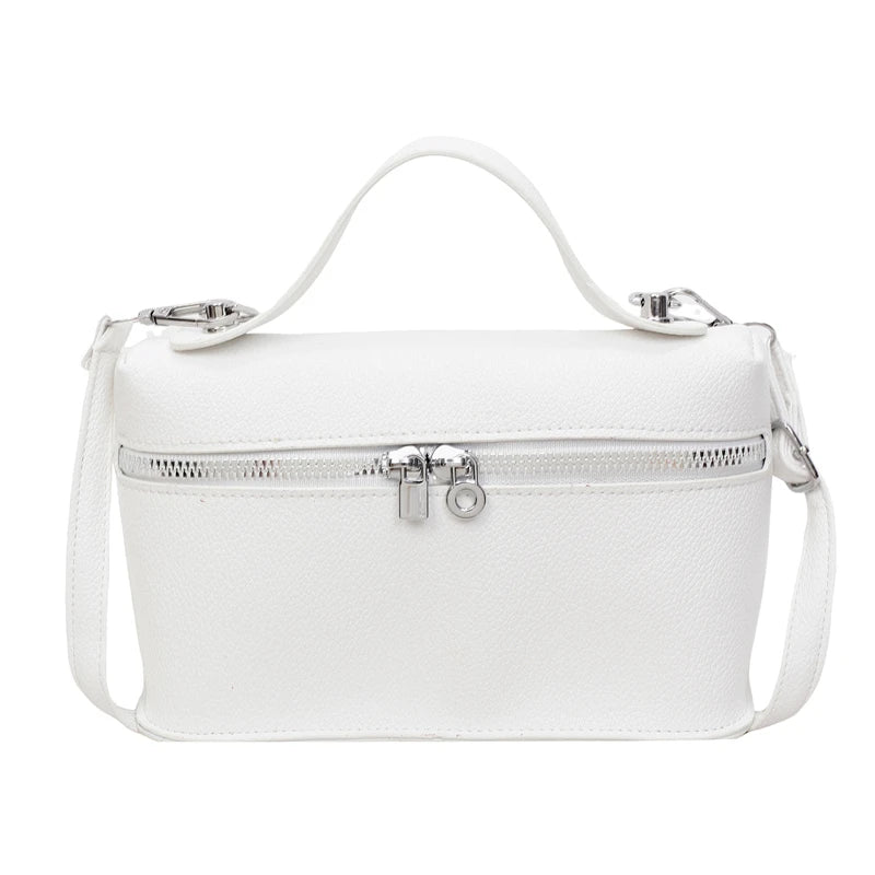 A white minimalist pebbled leather box crossbody bag with silver hardware and a white strap.