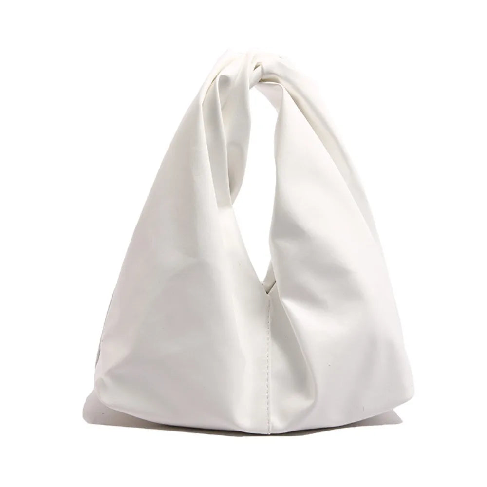 A white minimalist crossbody tote bag folded and displayed against a white background.