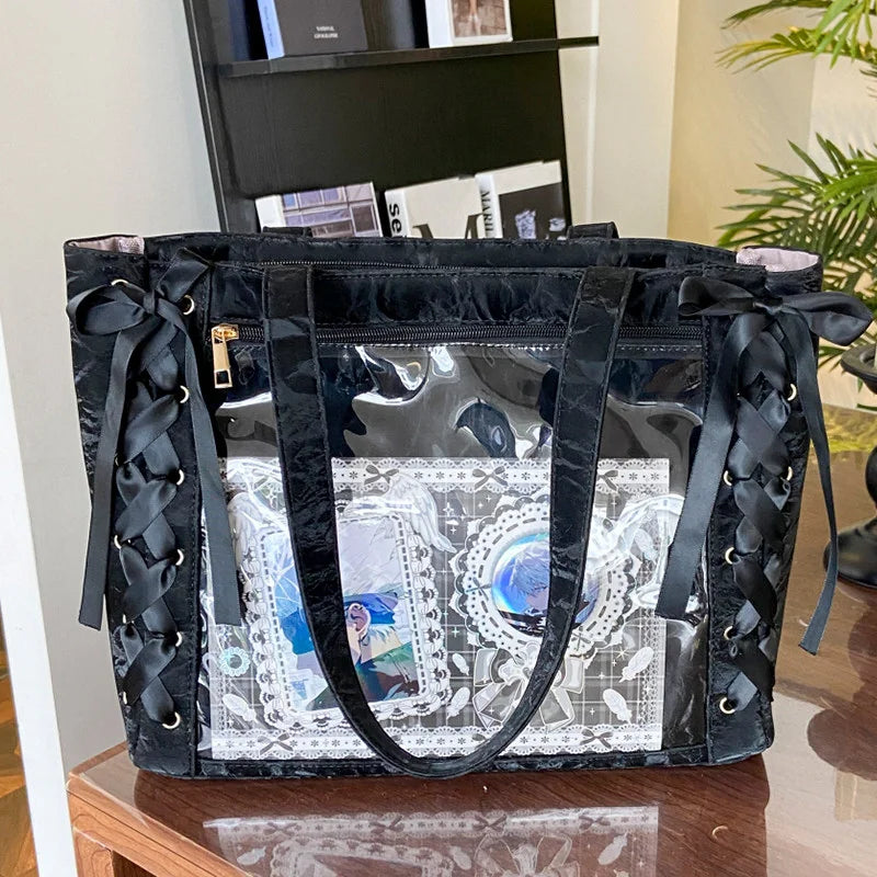 A black transparent shoulder tote bag with black leather straps and decorative elements.