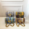 A set of elegant retro crossbody bags in black and gold patterned fabric with gold chain straps displayed on a white surface.