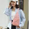 Eine Frau in einem hellblauen Hemd hält eine pinke gesteppte wasserdichte Crossbody-Tasche und spricht mit einem Headset.