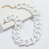 A white rope chain necklace with gold accents is displayed on a white box.