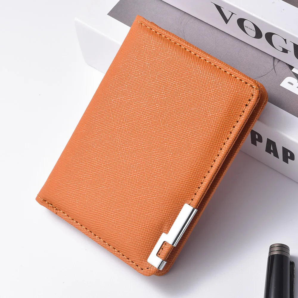 A rectangular orange faux leather business card wallet resting on a white surface next to a book.