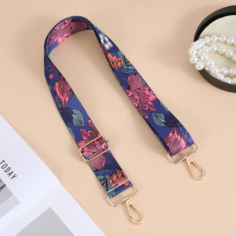 A floral patterned nylon crossbody bag strap with a gold-toned metal buckle displayed on a light background.