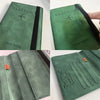 A green vintage PU leather passport wallet with a black zipper and embossed text.