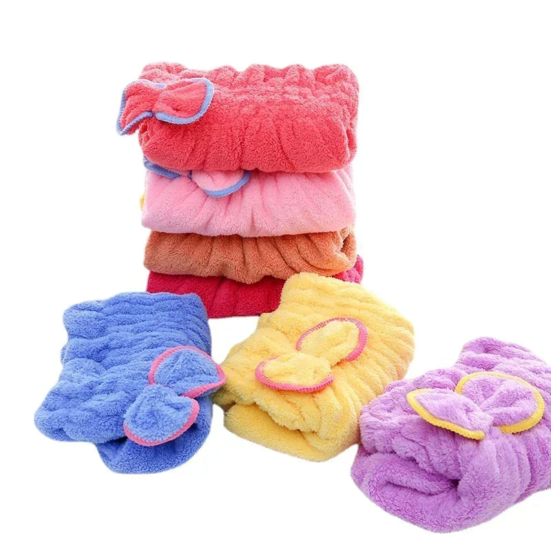 Colección de toallas y pañuelos de cabello de microfibra coloridos en tonos rosa, naranja, púrpura y azul.