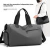 A gray waterproof travel duffle bag with a separate shoe compartment is shown next to a person.