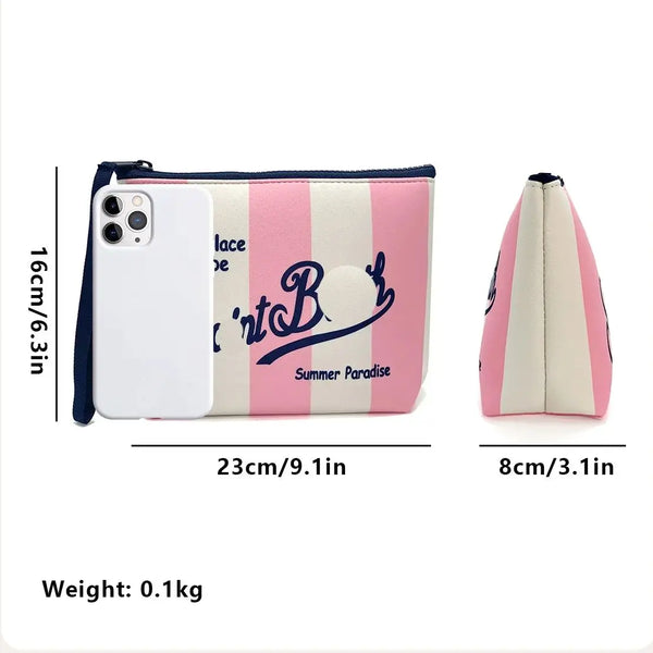 Bolsa cosmética a rayas rosa y blanca con un estuche de teléfono blanco y una bolsa de cuero separada.
