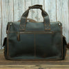 A dark brown genuine cowhide leather briefcase with leather handles and stitching set against a wooden background.