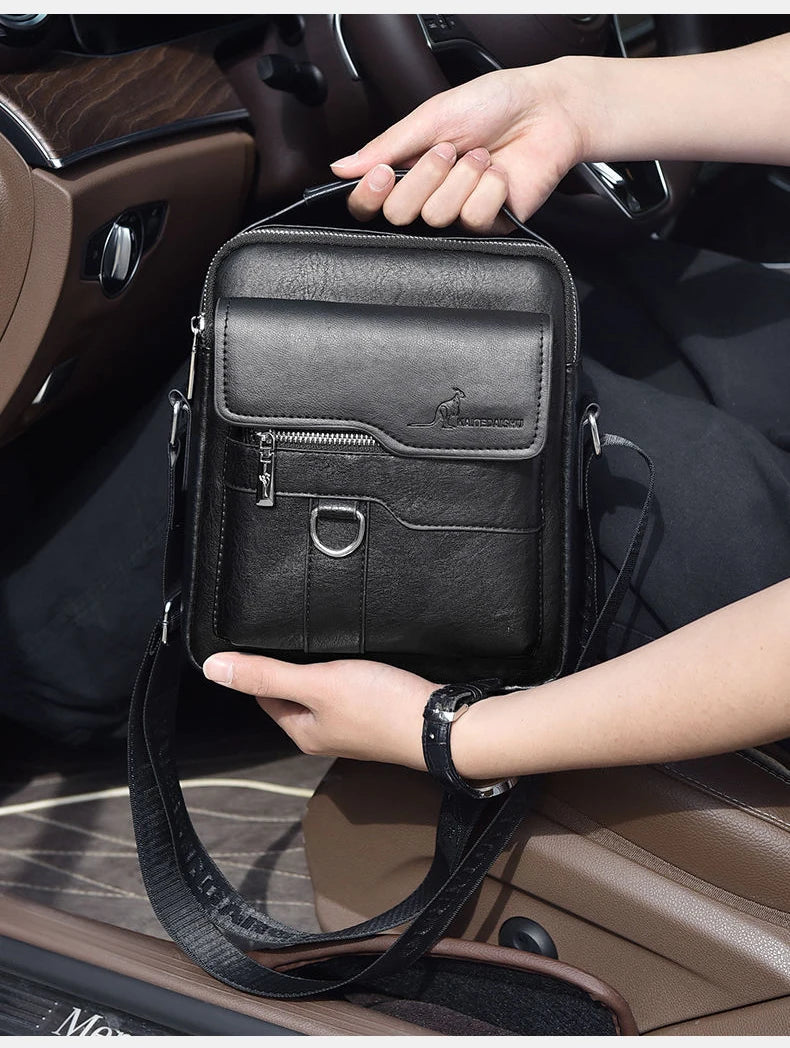 Una mano sostiene una vieja bolsa de cuero negro para mensajero en el interior de un coche.