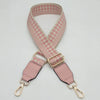 A pink and white checkered braided nylon bag strap with metal hooks.