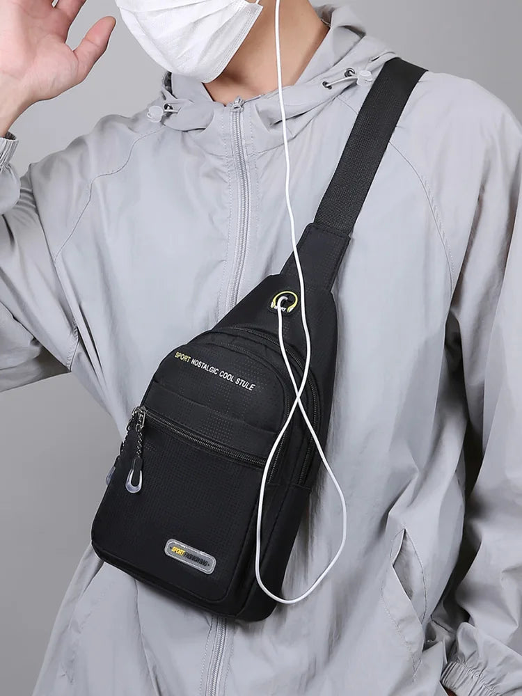A black sports nostalgic cool stule shoulder bag worn by a person in a gray jacket.