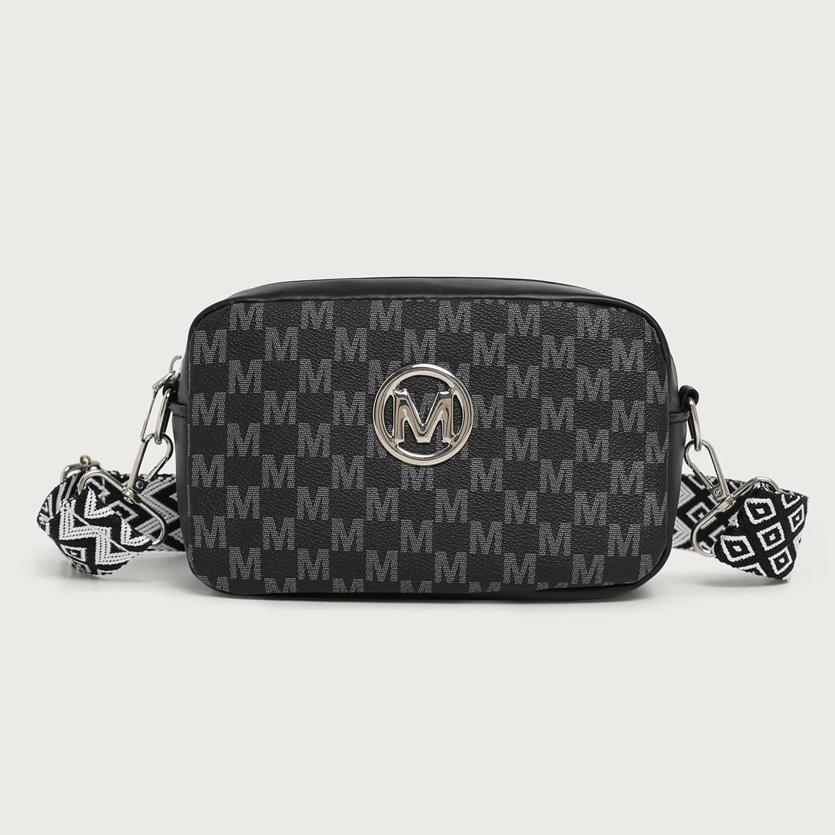 Black patterned crossbody bag with gold hardware and a decorative leather strap