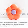 An orange flower-shaped phone grip ring stand with small black dots on the surface.