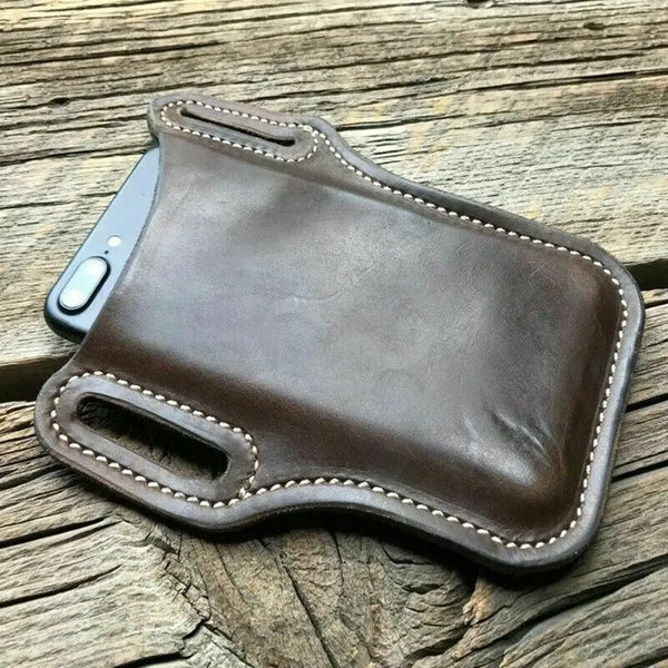 A brown leather phone and wallet belt pouch resting on weathered wooden planks.