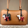 Bolso de cuero marrón con charm de perro Shiba Inu blanco y negro y un lazo de cuero rojo trenzado a mano.