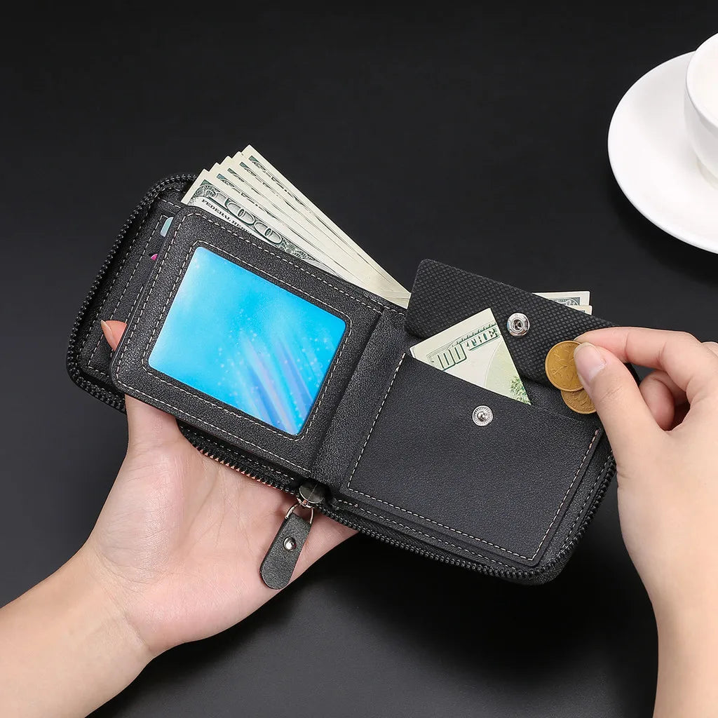 A black zippered wallet with a blue display and cash is held in a hand against a dark background.