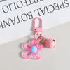 Pink resin flower keychain with a heart-shaped charm and a pink clasp