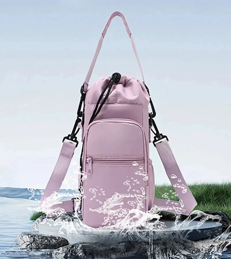 A pink adjustable strap thermal water bottle bag is shown splashing water on a rock surface.