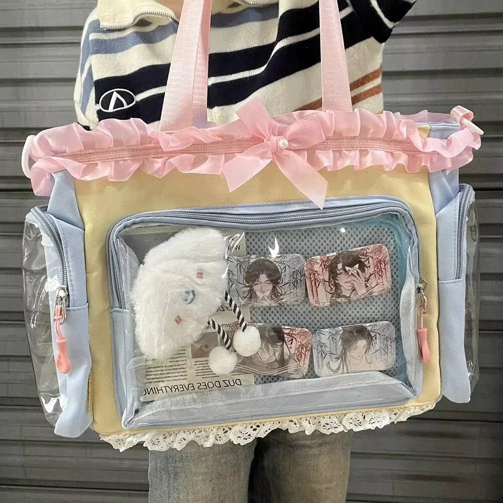 A transparent shoulder tote bag with a light yellow body, pink ribbon trim, and clear plastic pockets.