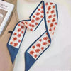 Foulard floral en soie bleu marine avec motif floral orange sur fond blanc.