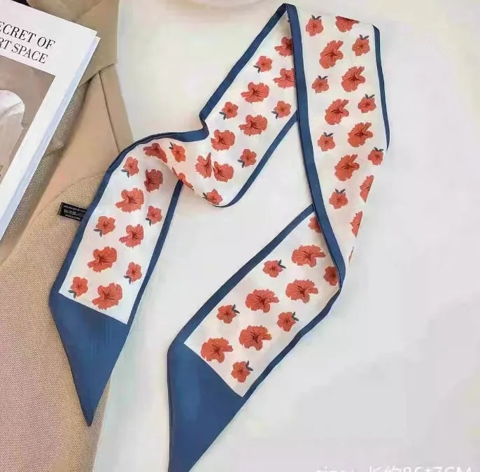 Foulard floral en soie bleu marine avec motif floral orange sur fond blanc.
