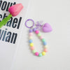 A colorful bead keychain featuring a heart charm and an O-ring clip, with beads in shades of pink, purple, blue, and yellow.