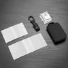 A black RFID zipper wallet is shown next to a stack of US dollar bills and several white plastic cards on a dark surface.