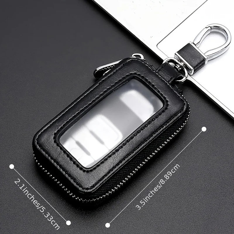 Black retro PU leather car key case with a clear window and metal hook resting on a dark surface.