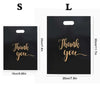 Two black plastic gift bags labeled S and L with gold script text Thank you