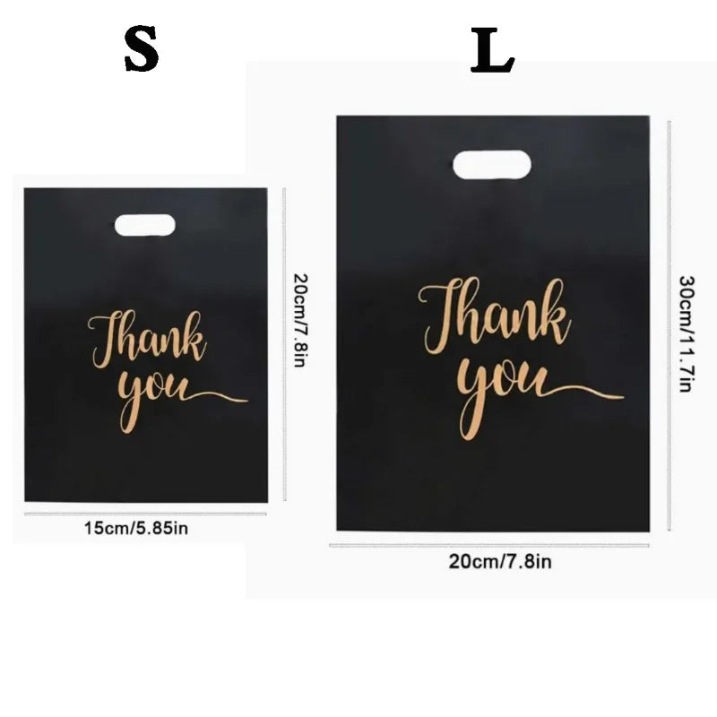 Two black plastic gift bags labeled S and L with gold script text Thank you