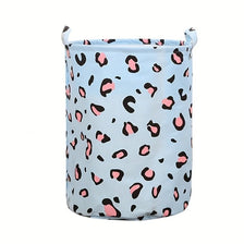 A light blue fabric laundry basket with a leopard print pattern.