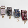 Cuatro correas ajustables para bolso cruz en morado, negro, azul y rojo con patrones paisley.