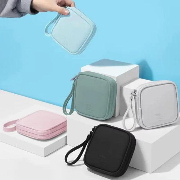 Une collection de pochettes de rangement pour écouteurs portables dans les tons bleu clair, vert menthe et noir, présentées s