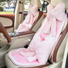 Pink bowknot car headrest pillow with lumbar support in a beige car interior.