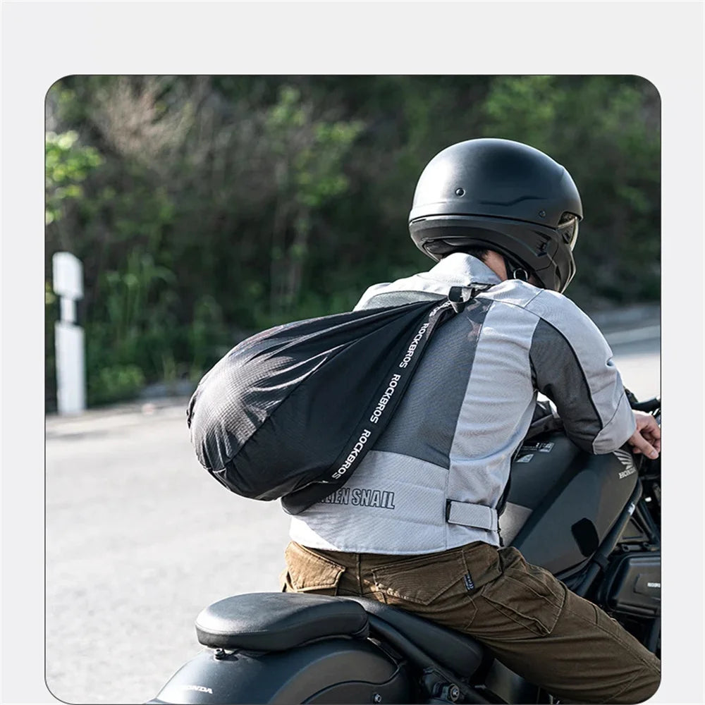 A person wearing a black helmet with a backpack is sitting on a motorcycle in an outdoor setting.