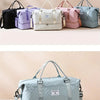A collection of multicolored duffel bags and a light blue travel duffel bag with a zipper.