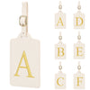 Un ensemble de étiquettes de bagages en cuir brodées personnalisées avec les lettres A à F sur fond crème.