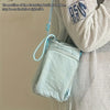 A light blue adjustable water bottle carrier bag with a phone pocket is shown attached to a person's clothing.