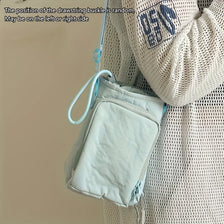 A light blue adjustable water bottle carrier bag with a phone pocket is shown attached to a person's clothing.